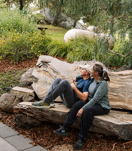 A man and woman sitting on a log bench