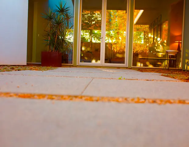 A stone walkway leading up to a glass door