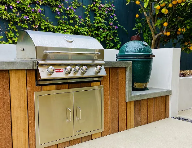A gas grill built into a backyard