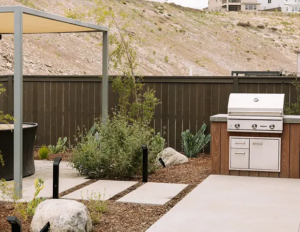 A backyard grill next to plants