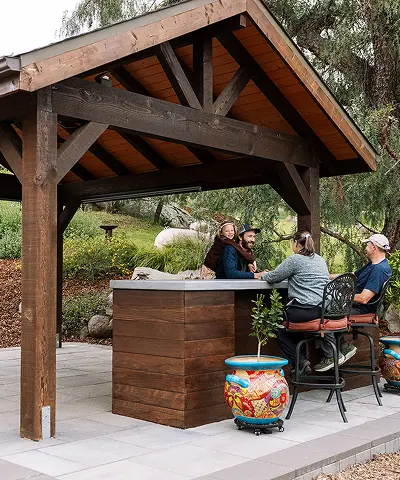 An outdoor space with people gathered sitting at a counter