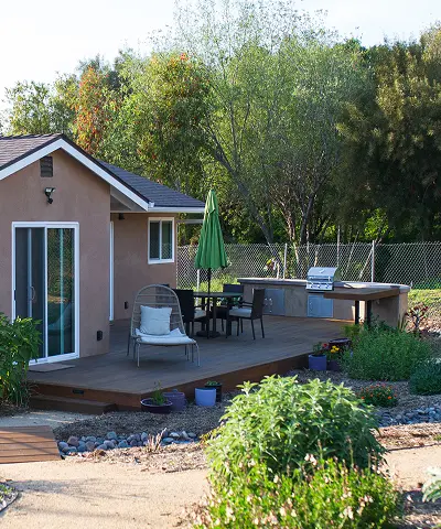 An outdoor kitchen completed by patio furniture with an umbrella