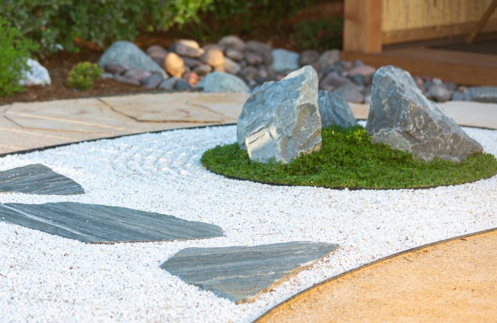Boulder set in raked aggregate with kurapia groundcover