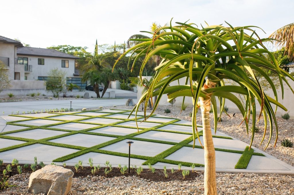Modern Front yard with concrete and turf driveway and drought-tolerant plants.
